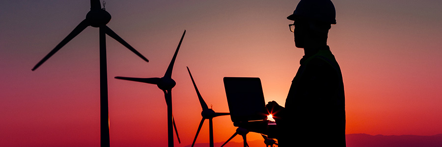 Silhouette of worker with wind turbines in the distance