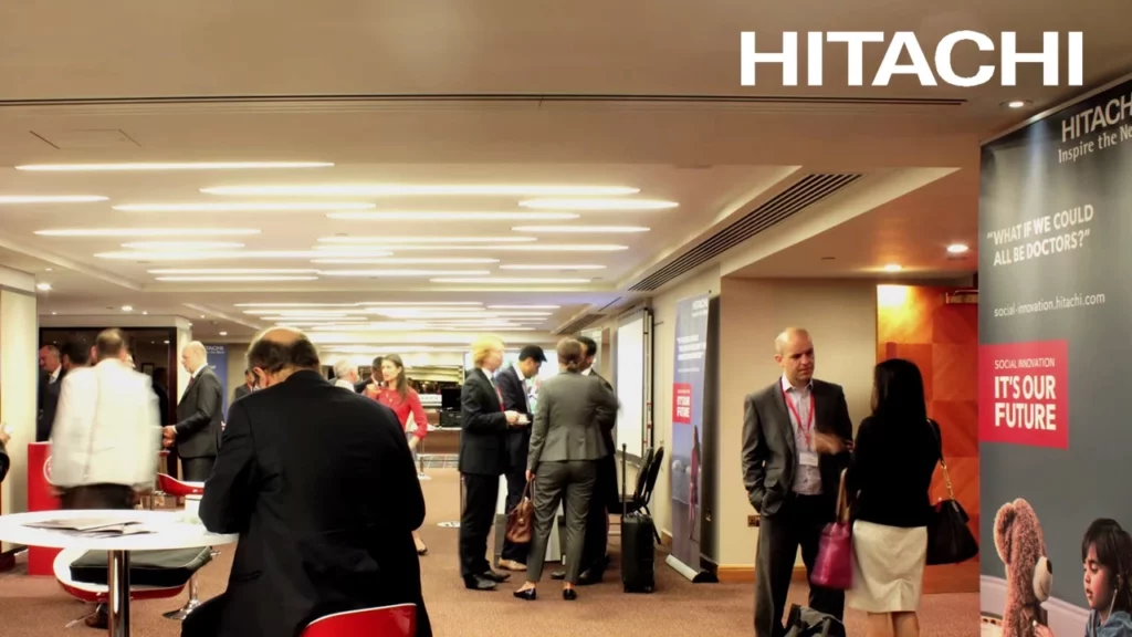 People in conversation during an Hitachi conference
