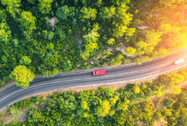 Red Truck driving in Forest Drone shot
